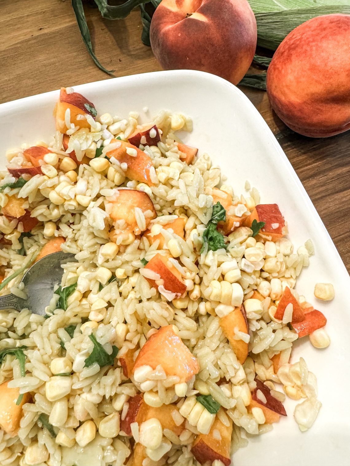 Sweet peaches and corn summer orzo salad - orzo with peaches, corn, arugula topped with a hot honey dressing.